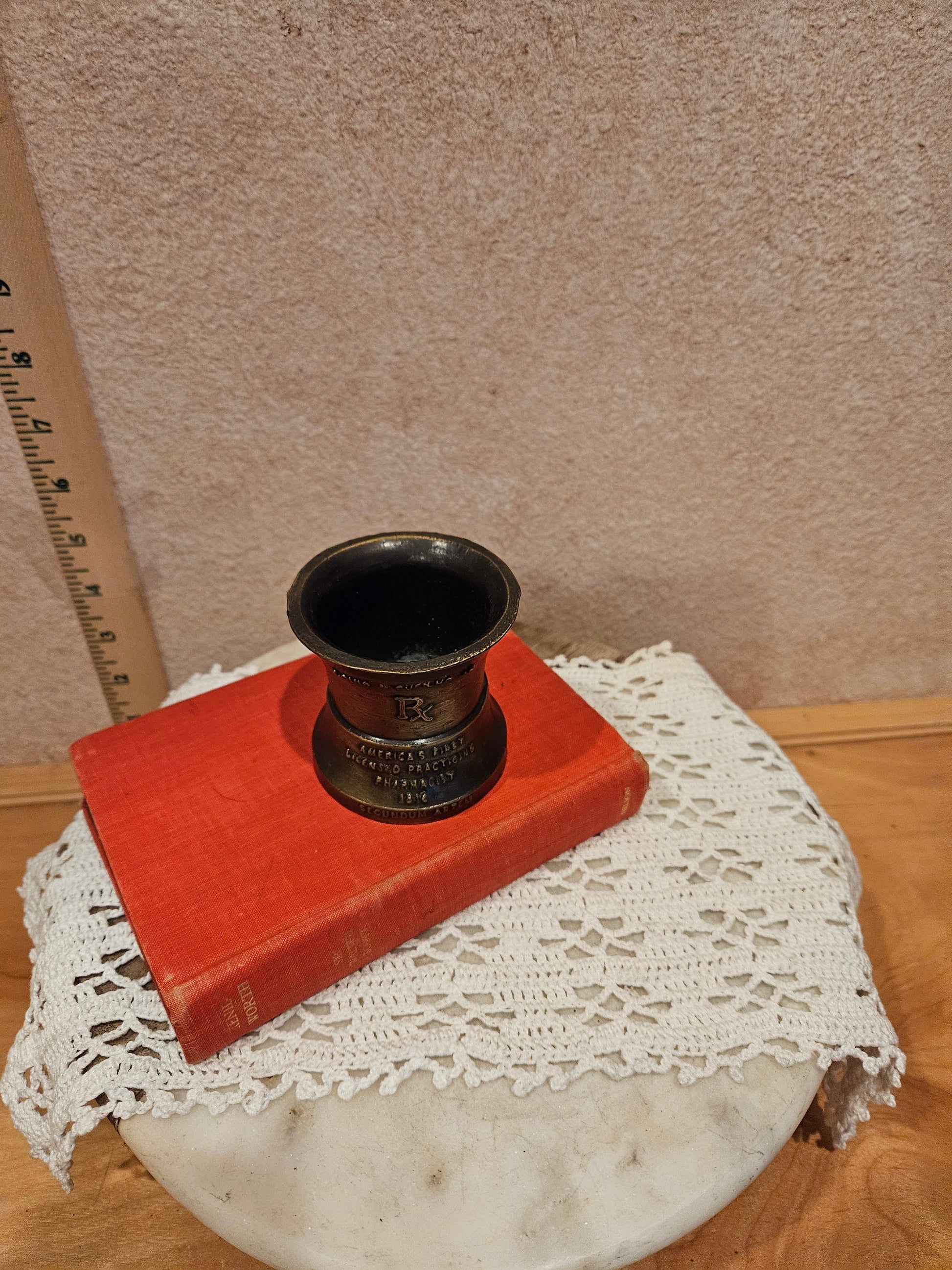 A vintage bronze pharmacy mortar and pestle, a symbol of the pharmacy profession, featuring intricate designs and historical inscriptions.