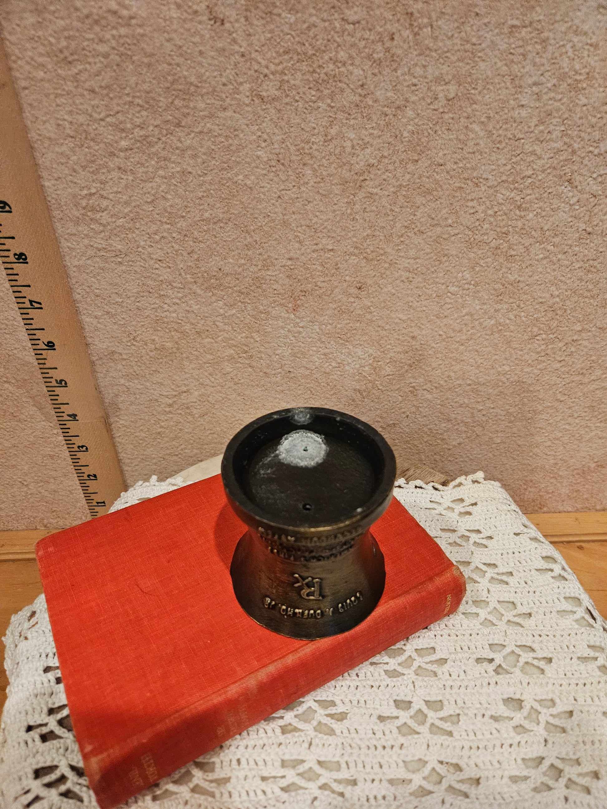 A vintage bronze pharmacy mortar and pestle, a symbol of the pharmacy profession, featuring intricate designs and historical inscriptions.