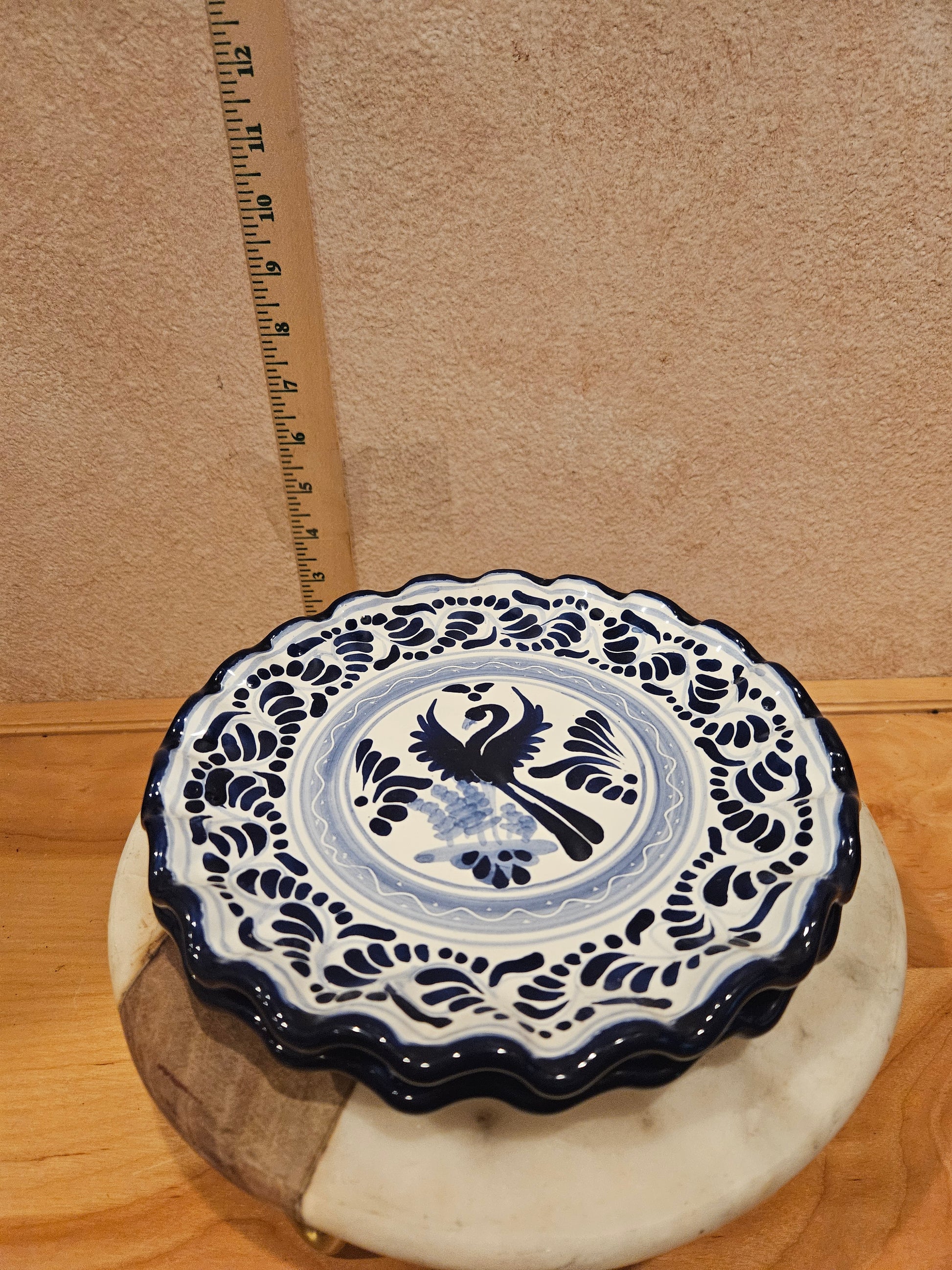 A beautiful decorative blue and white ceramic dish with a scalloped edge and intricate designs, perfect for home decor or serving purposes.