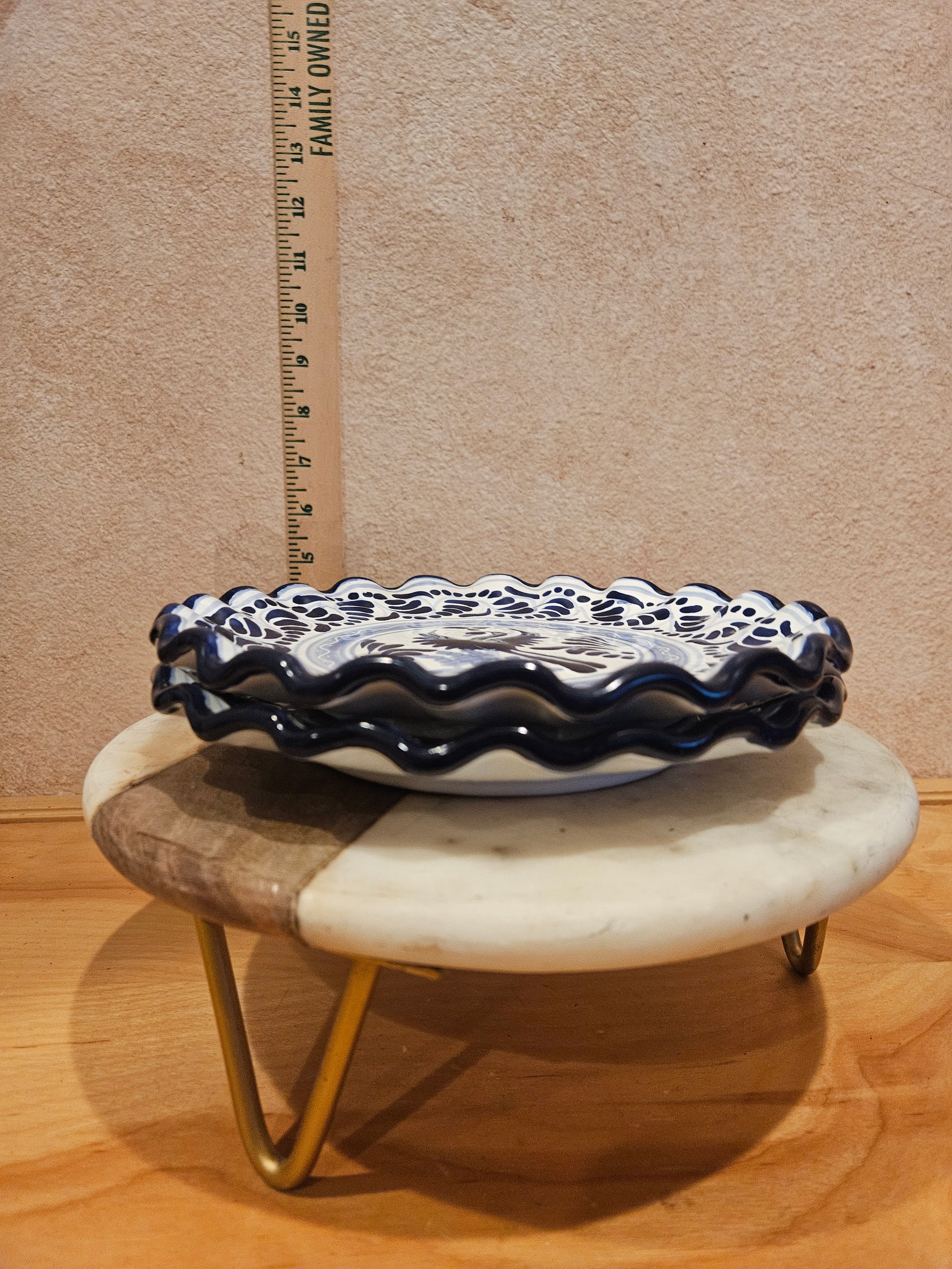 A beautiful decorative blue and white ceramic dish with a scalloped edge and intricate designs, perfect for home decor or serving purposes.