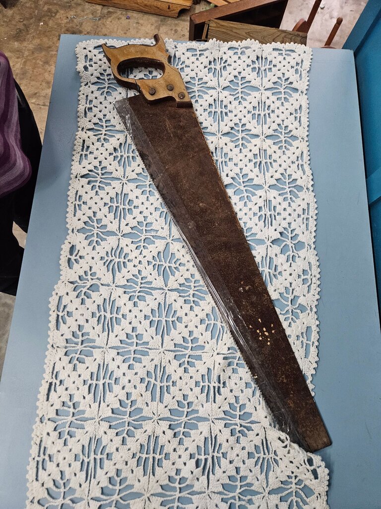 A vintage hand saw with a wooden handle, perfect for collectors or DIY enthusiasts.