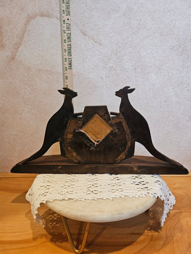 Antique decorative wooden kangaroos flanking central shield-like mirror, resting on a base